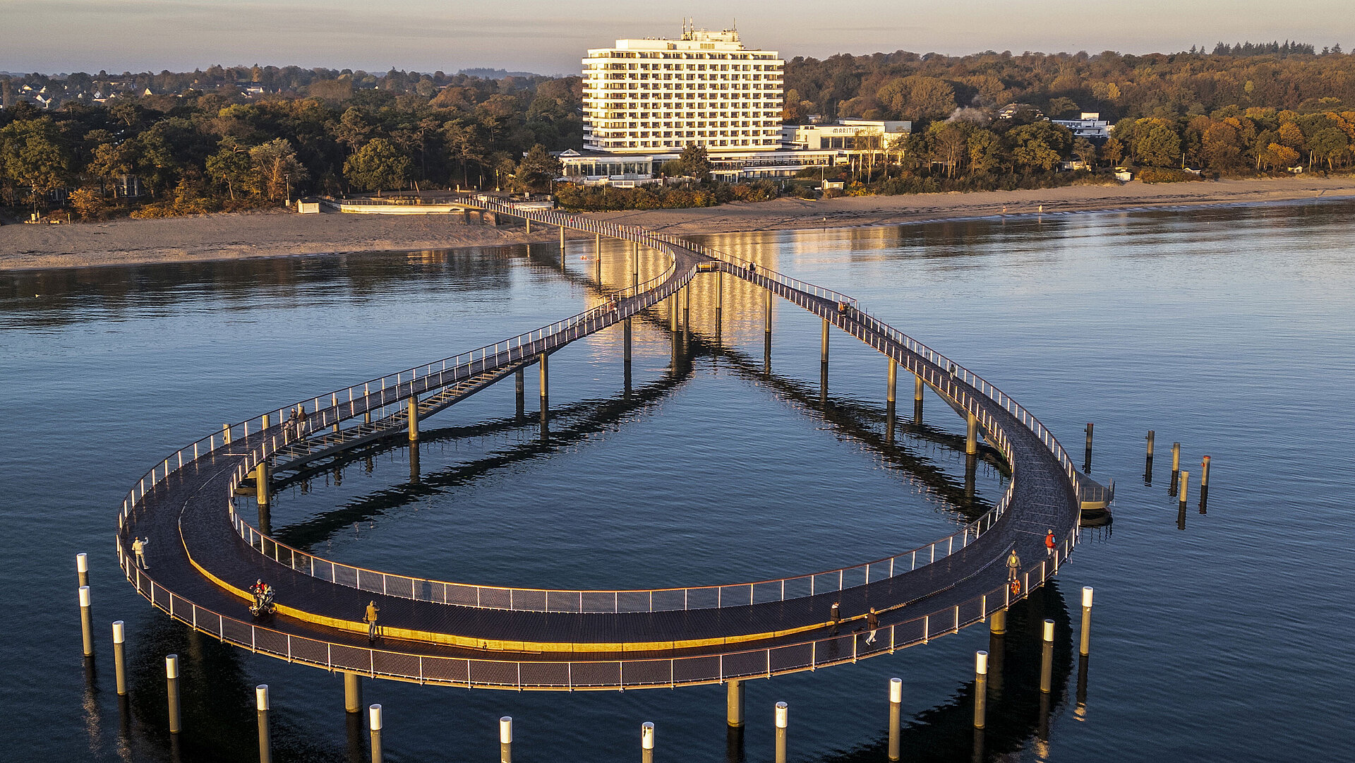 Illuminated pier at dusk in front of the Maritim Seehotel Timmendorfer Strand.