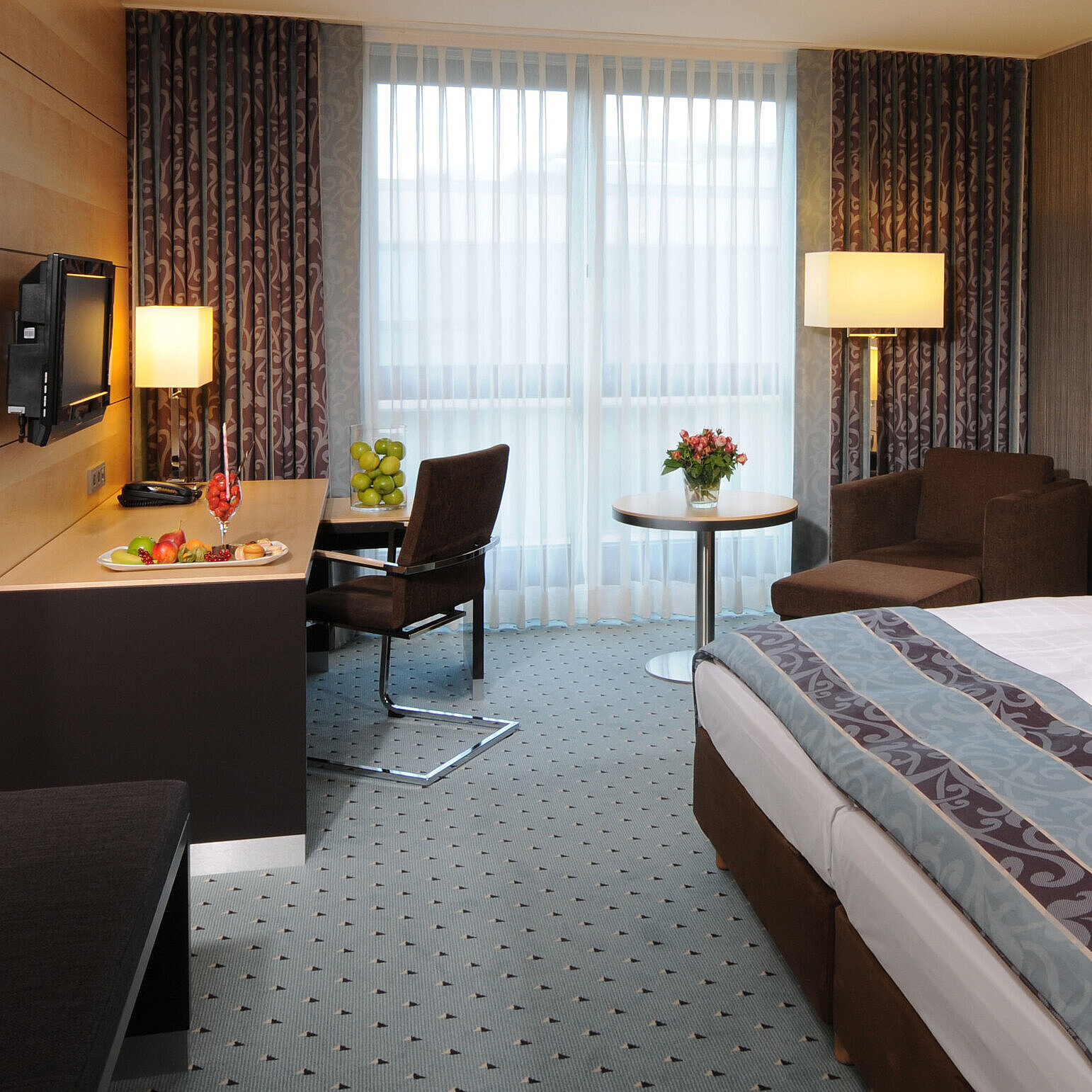 Camera Superior al Maritim Hotel Düsseldorf con letto matrimoniale elegante, scrivania moderna, area salotto accogliente.