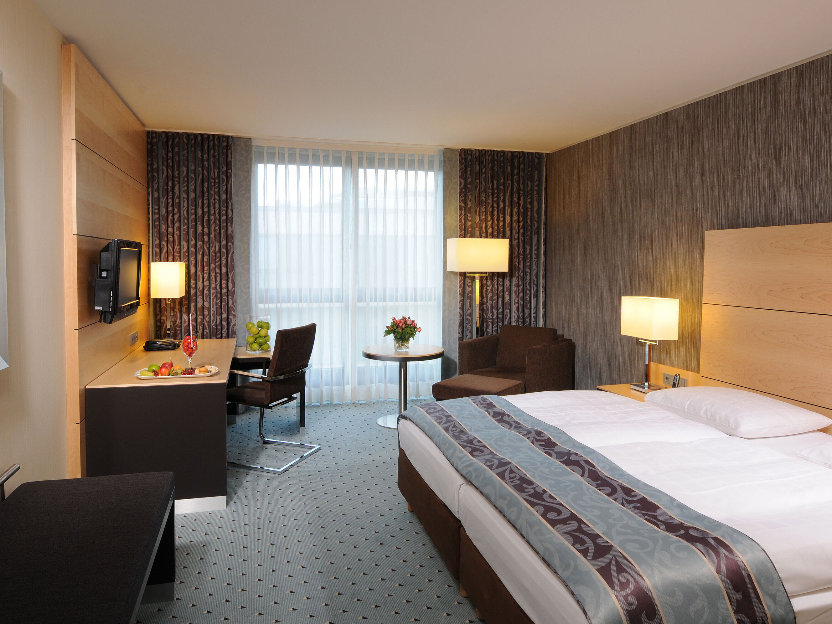 Superior room at Maritim Hotel Düsseldorf with stylish double bed, modern desk, cozy seating area, and fresh details.