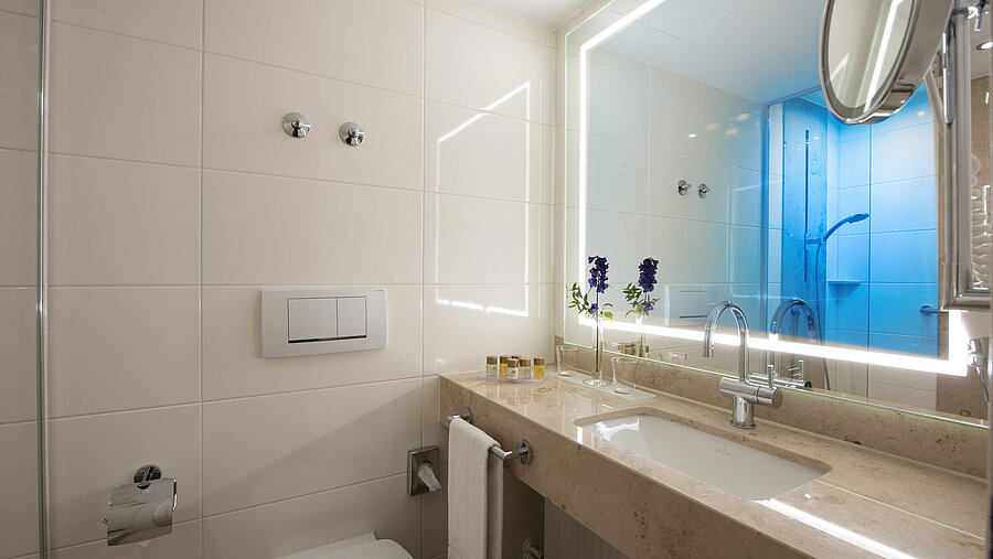 Baño luminoso con gran espejo y productos en el Maritim Hotel Titisee