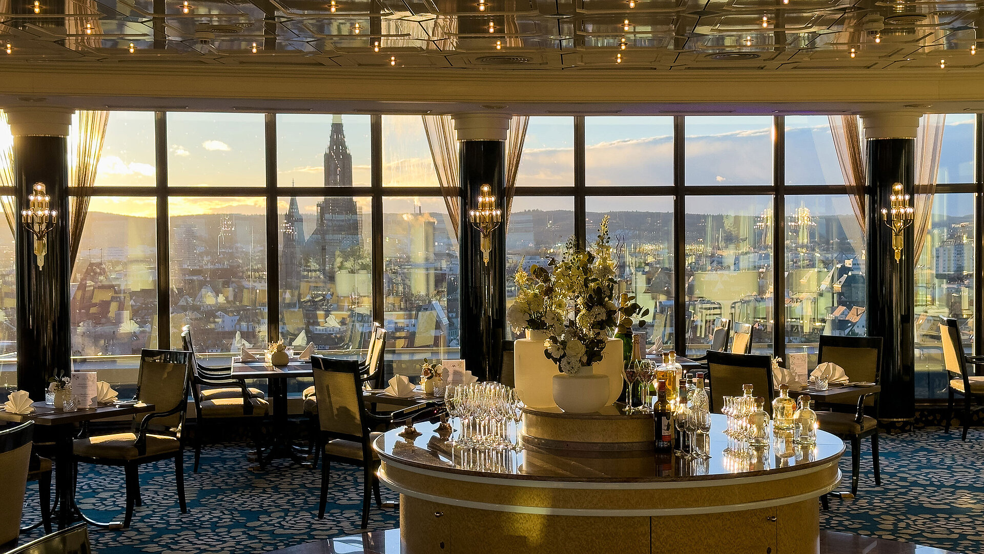 Elegant restaurant in Maritim Hotel Ulm with large panoramic windows overlooking the city at sunset