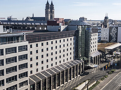 Vista esterna dell'hotel Maritim con facciata moderna e posizione centrale, circondato da edifici storici e vista sulla città.