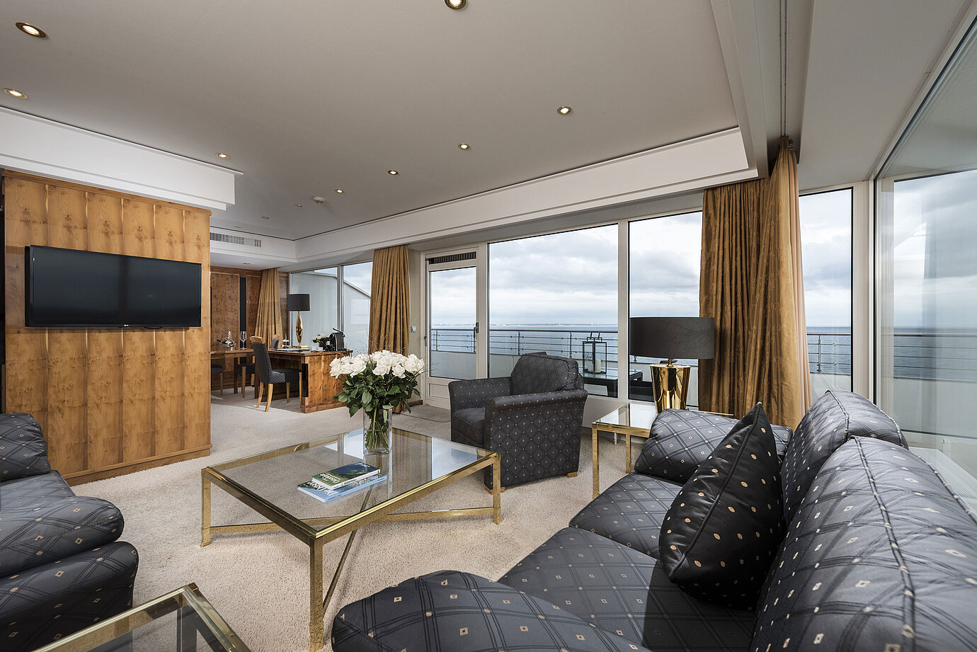 Penthouse living area with sea view, elegant furnishings, and large glass front at Maritim Seehotel Timmendorfer Strand.