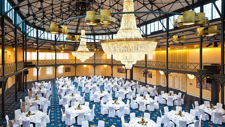 Gran salón con mesas redondas y candelabros en el Maritim Hotel Stuttgart