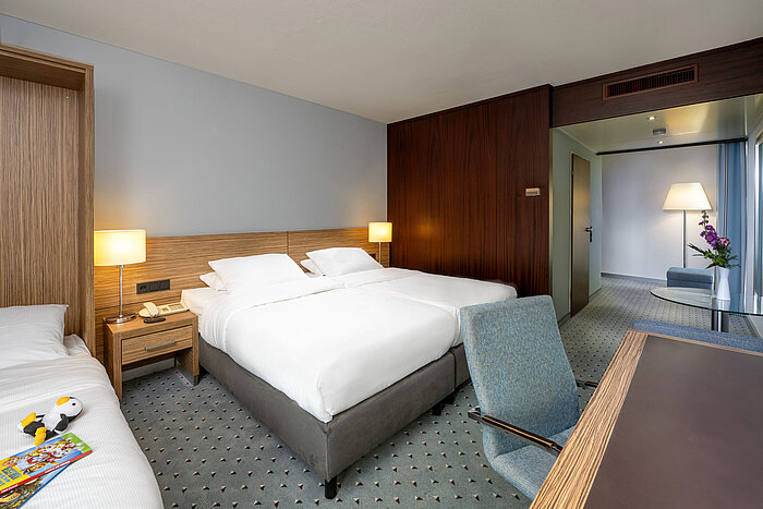 Vista sulla Camera Familiare Comfort del Maritim Hotel Darmstadt con tre letti e una zona giorno separata