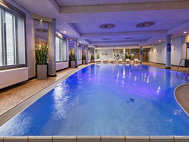 Illuminated indoor pool at Maritim Hotel Frankfurt with a relaxing atmosphere and panoramic windows.