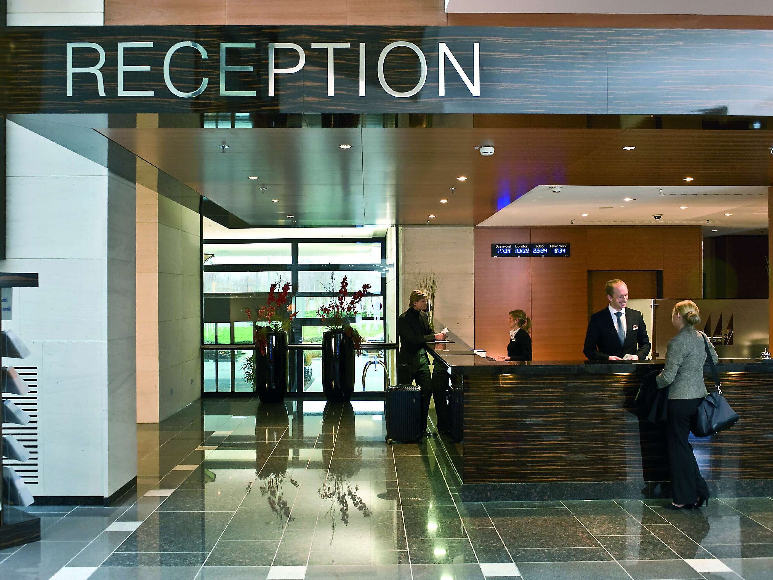 Reception at Maritim Hotel Düsseldorf with friendly staff and modern design, perfect for check-ins and guest services.