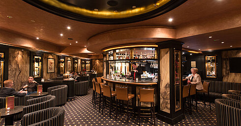 Bar d'hôtel élégante au Maritim Hotel Fulda avec ambiance chaleureuse, comptoir raffiné et salon cosy.