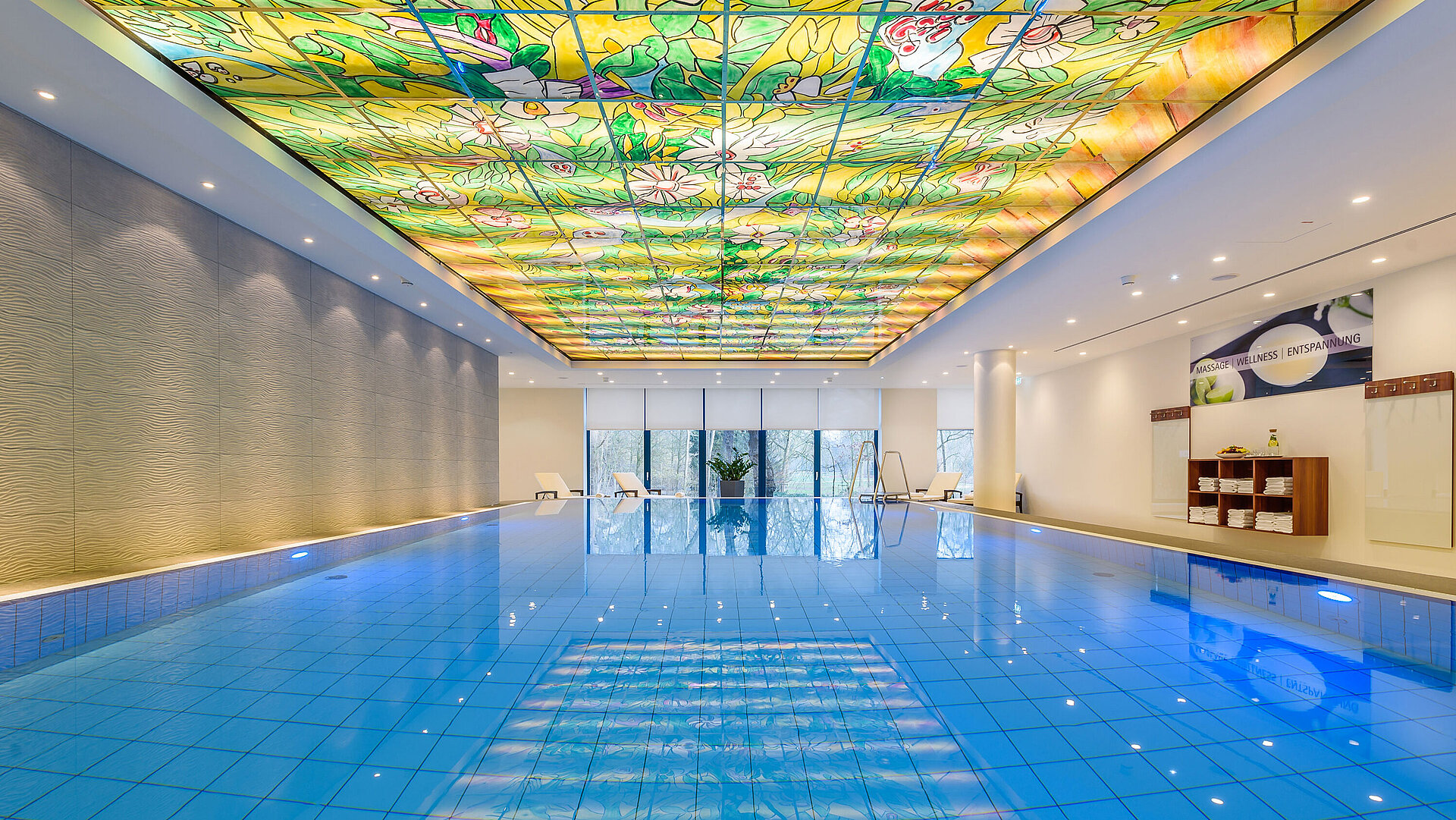 Elegante area piscina al Maritim Bremen con soffitto in vetro colorato e illuminazione moderna,perfetta per relax e benessere