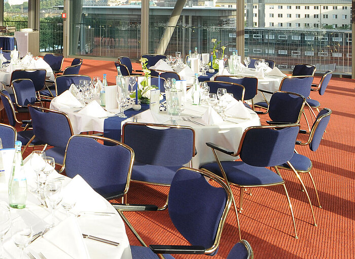 Elegante sala de eventos del Maritim Hotel Dresde con mesas decoradas y vista a la ciudad.