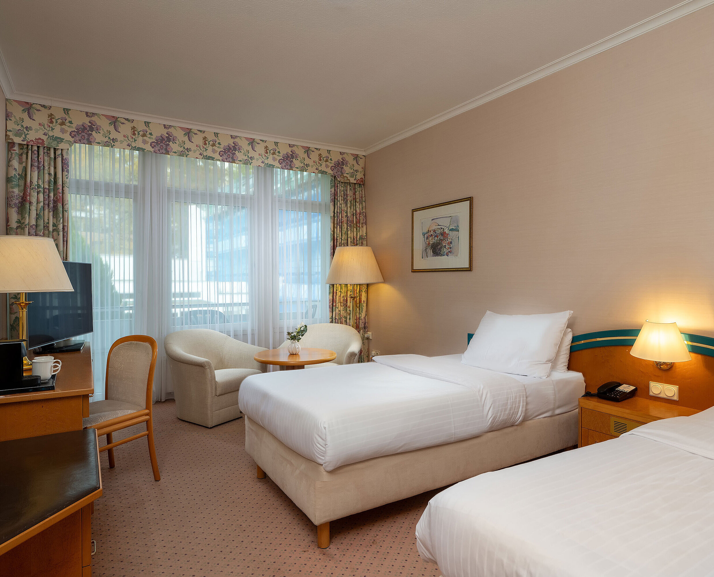 Comfort Twin room with two single beds, desk, seating area and large window for plenty of daylight.