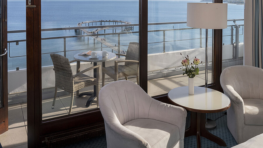 Hotel room with seating area and balcony with sea view at Maritim Seehotel Timmendorfer Strand.