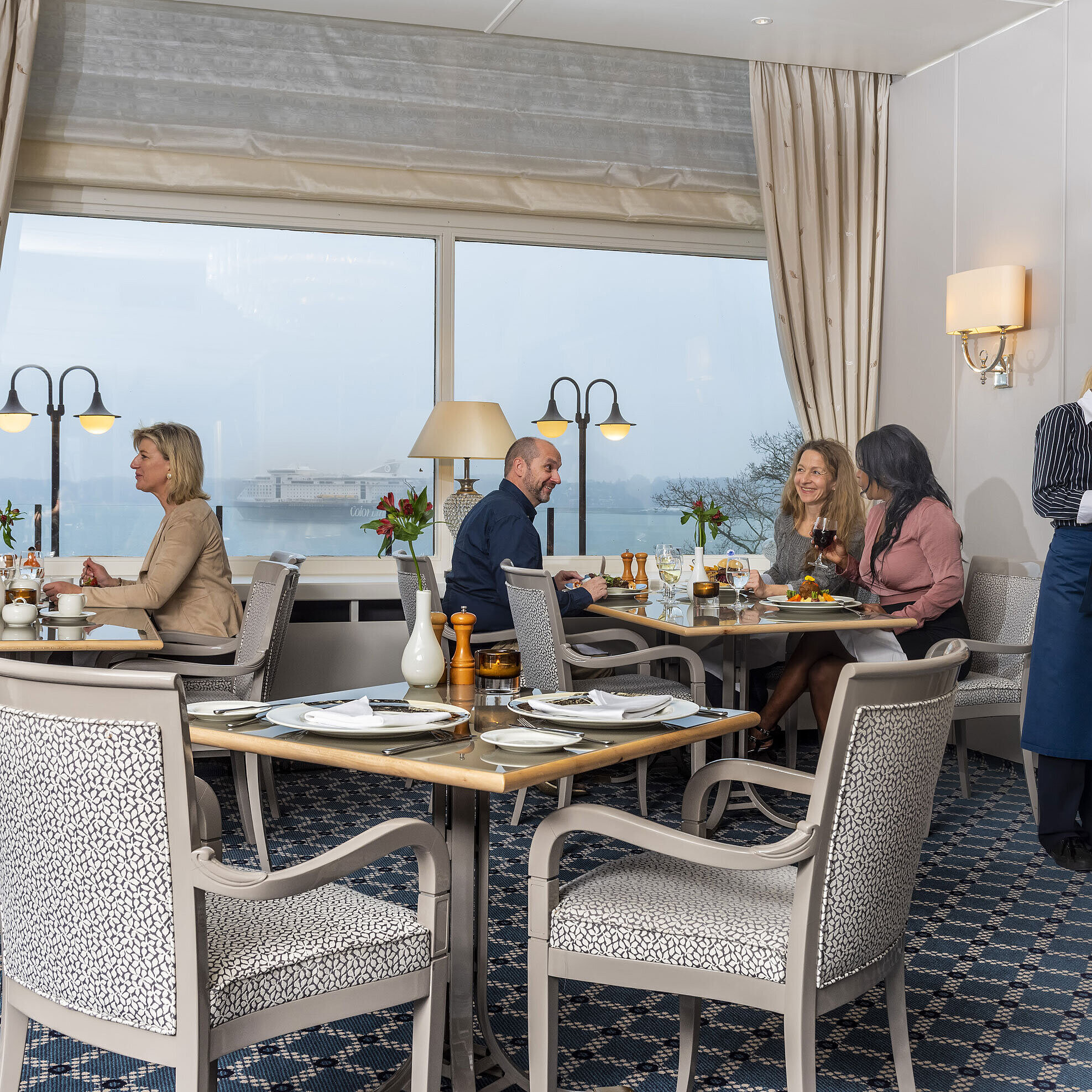 The Bellevue restaurant in the Maritim Hotel Kiel, guests enjoy meals with a sea view, friendly service in stylish surroundings.