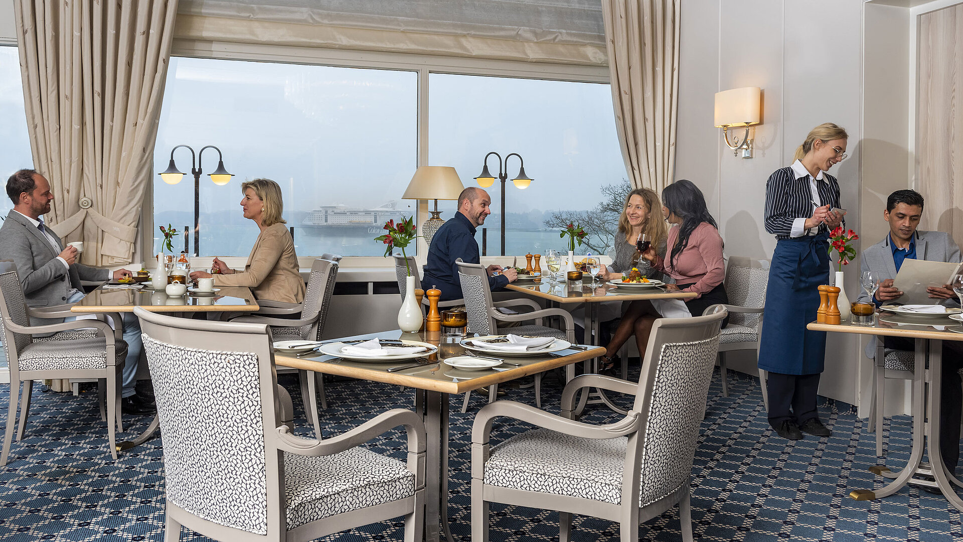 The Bellevue restaurant in the Maritim Hotel Kiel, guests enjoy meals with a sea view, friendly service in stylish surroundings.