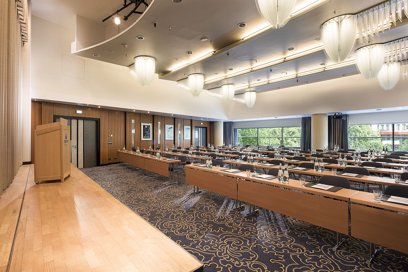 Sala de conferencias con escenario y ventanas panorámicas en el Maritim Hotel Frankfurt. Filas de asientos y diseño moderno.