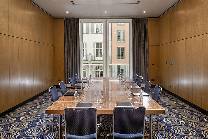 Salle de réunion lumineuse Salon I à l'Hôtel Maritim proArte Berlin avec grande table de conférence et vue sur l'extérieur.