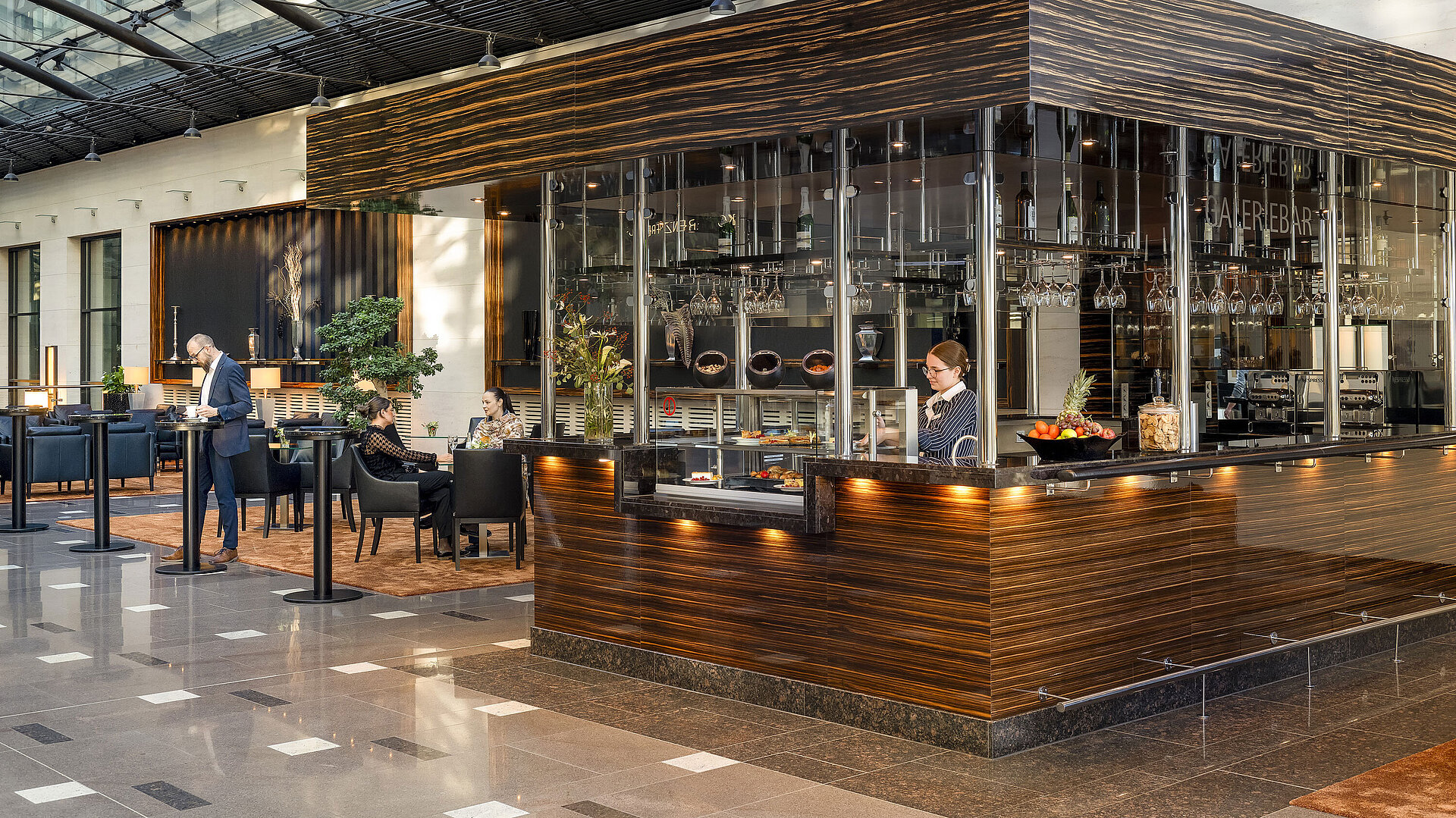 Modern Café at Maritim Hotel Düsseldorf with elegant design, cozy seating areas, and a staff member behind the counter