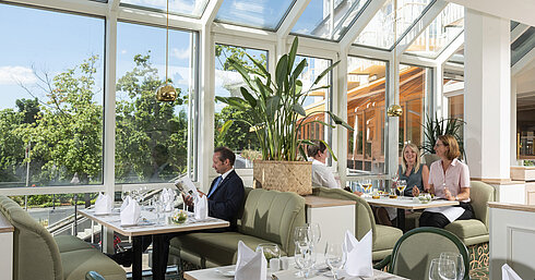 Restaurante espacioso en el Maritim Hotel Würzburg con ventanales panorámicos y zona de estar acogedora