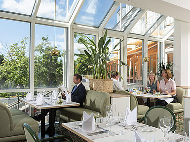 Restaurante espacioso en el Maritim Hotel Würzburg con ventanales panorámicos y zona de estar acogedora