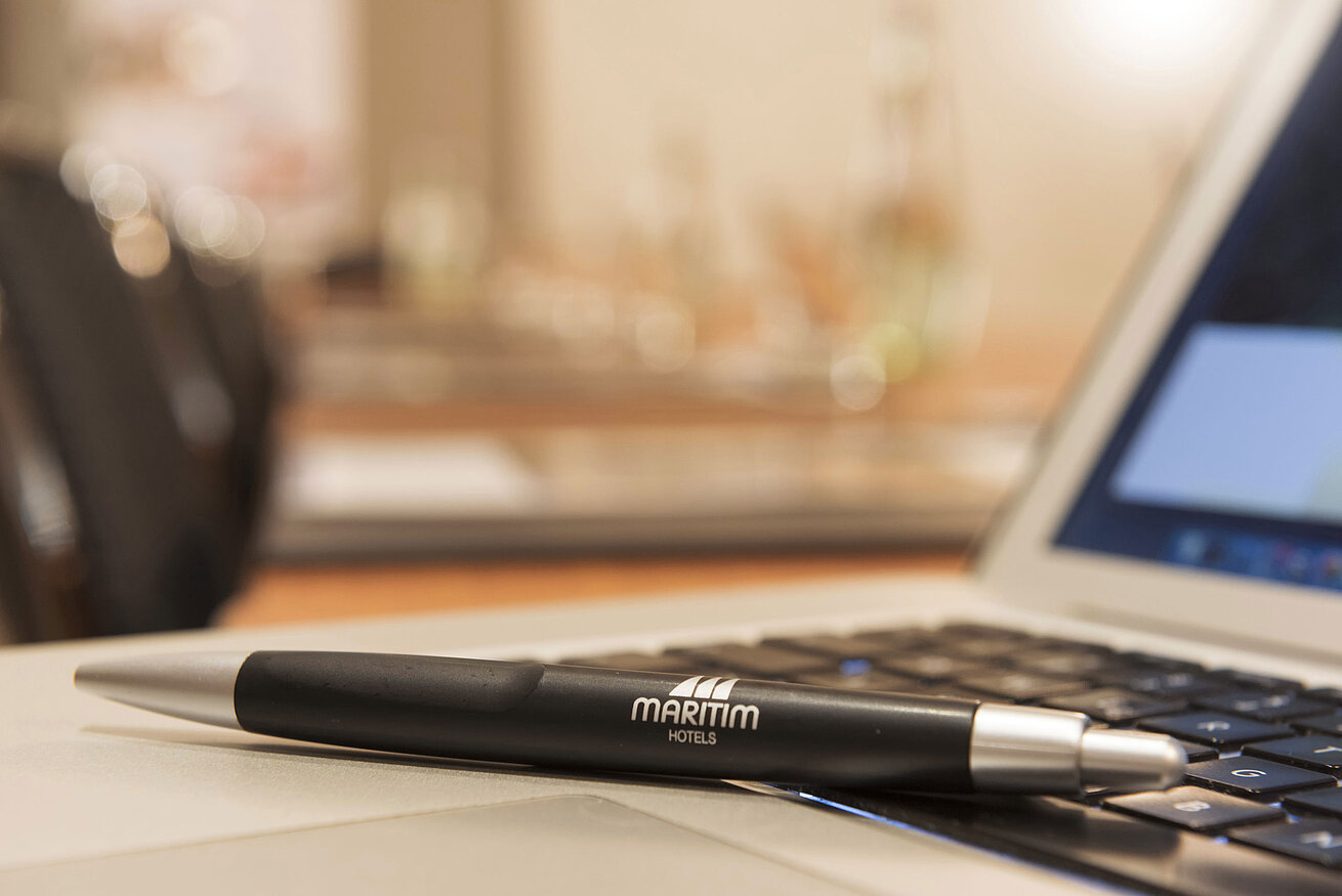 Penna con logo Maritim su laptop nella sala riunioni del Maritim Hotel Monaco