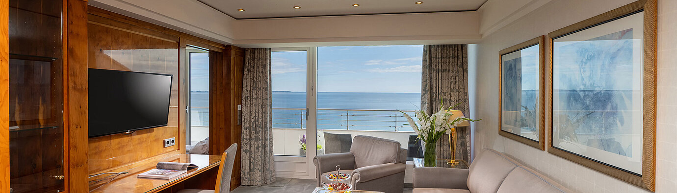 Soggiorno luminoso della suite al Maritim Seehotel Timmendorfer Strand con vista mare e zona salotto