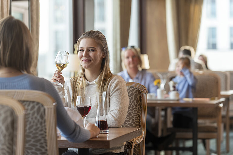 Mujer con vino blanco en el elegante restaurante del Maritim Hotel Travemünde