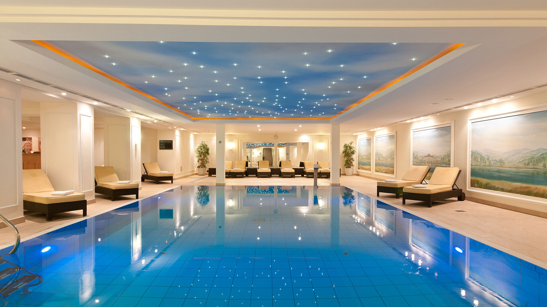 Piscine Piscine intérieure luxueuse au Maritim Hotel Dresden avec transats et éclairage d'ambiance au plafond.