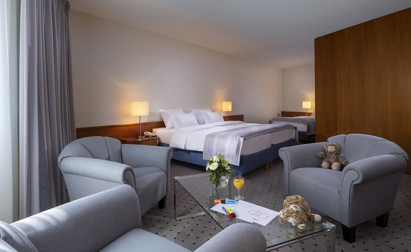 Habitación familiar en Maritim Hotel Hannover con cama doble, cama individual, área de descanso y detalles encantadores.