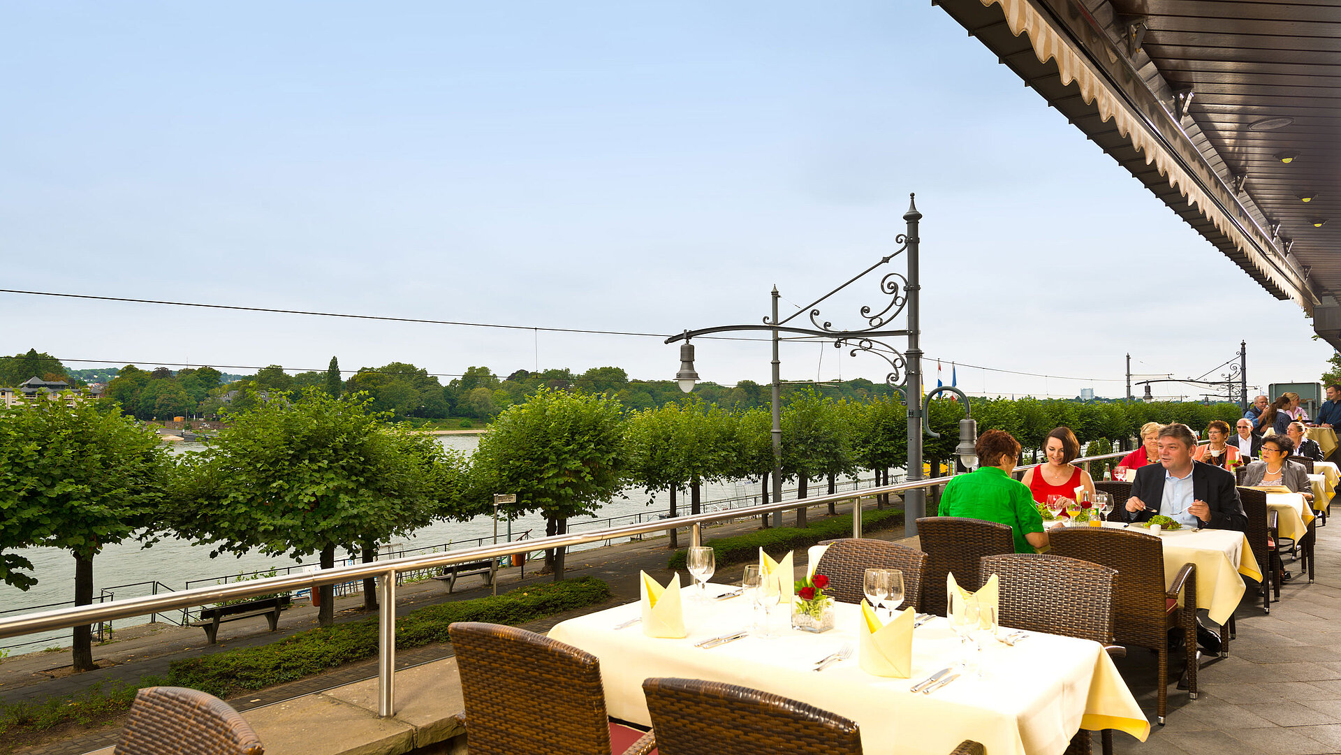 Outdoor terrace at Maritim Hotel Königswinter with Rhine view, elegantly set tables, and relaxed atmosphere.