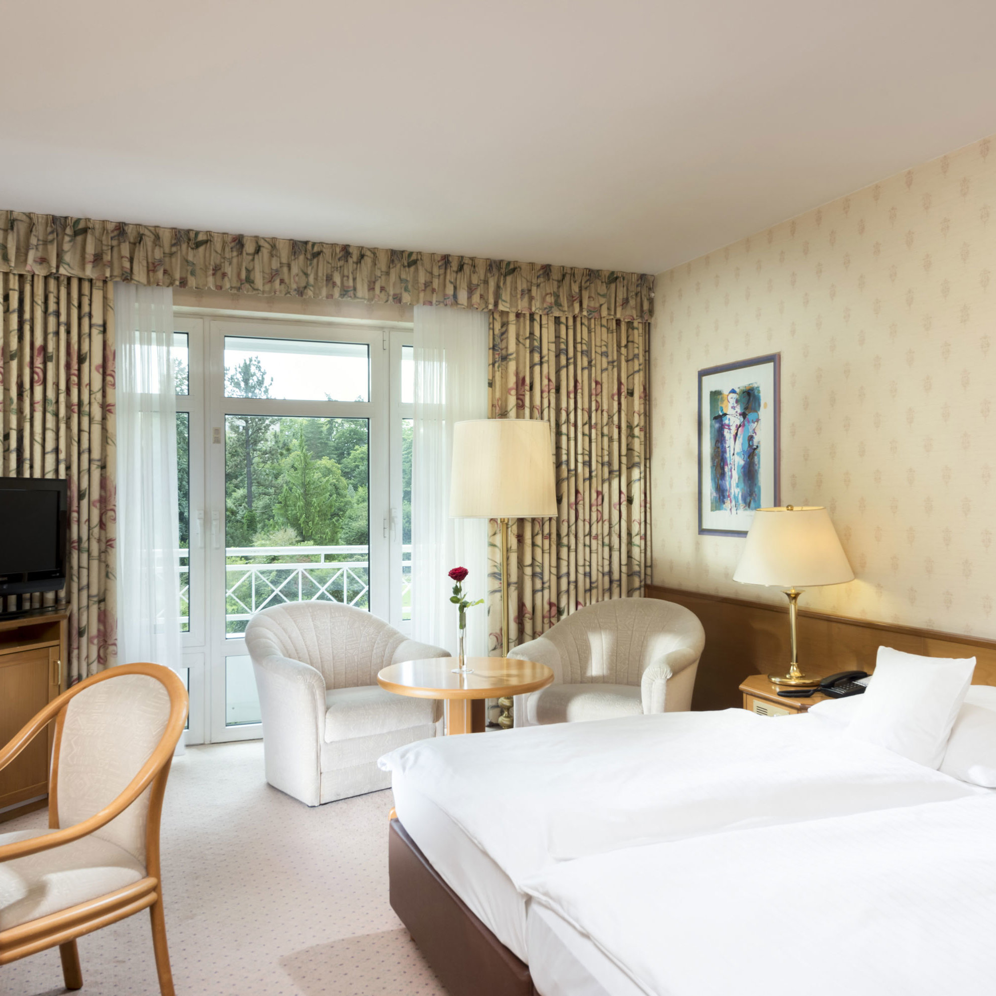 Bright double room with balcony view and seating area at Maritim Hotel Bad Wildungen