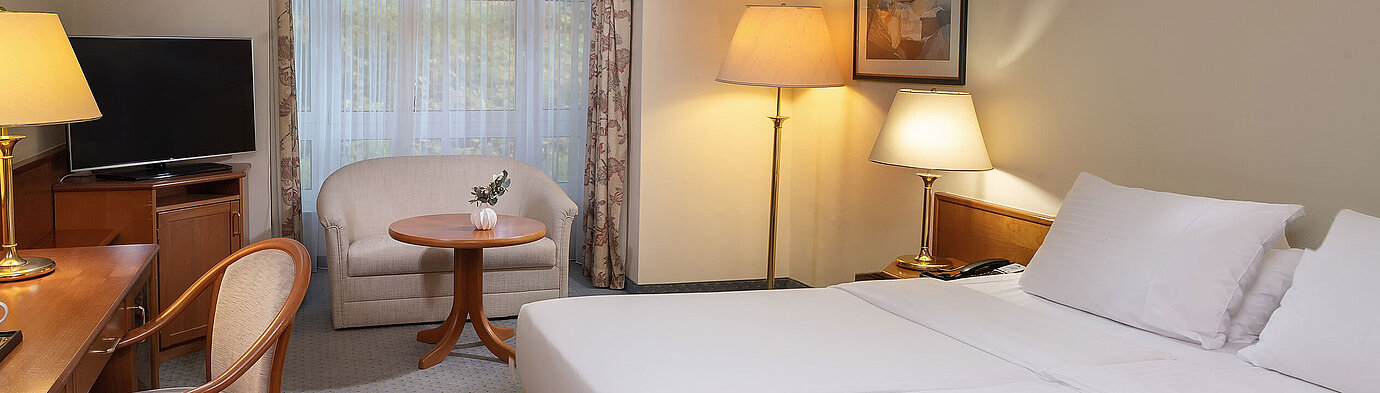 Camera Classic Camera Classic con letto doppio, scrivania, TV, area salotto e ampia finestra in un ambiente luminoso.