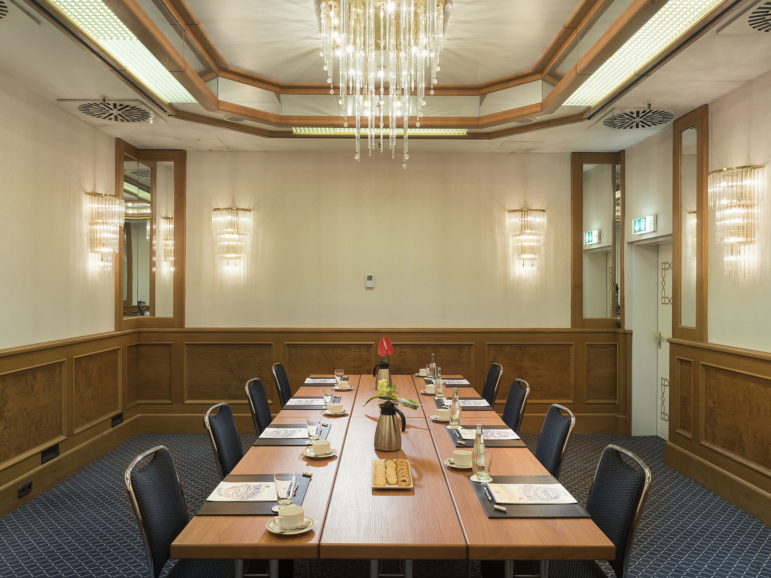 Sala pequeña con café, galletas y flores en el Maritim Hotel Múnich