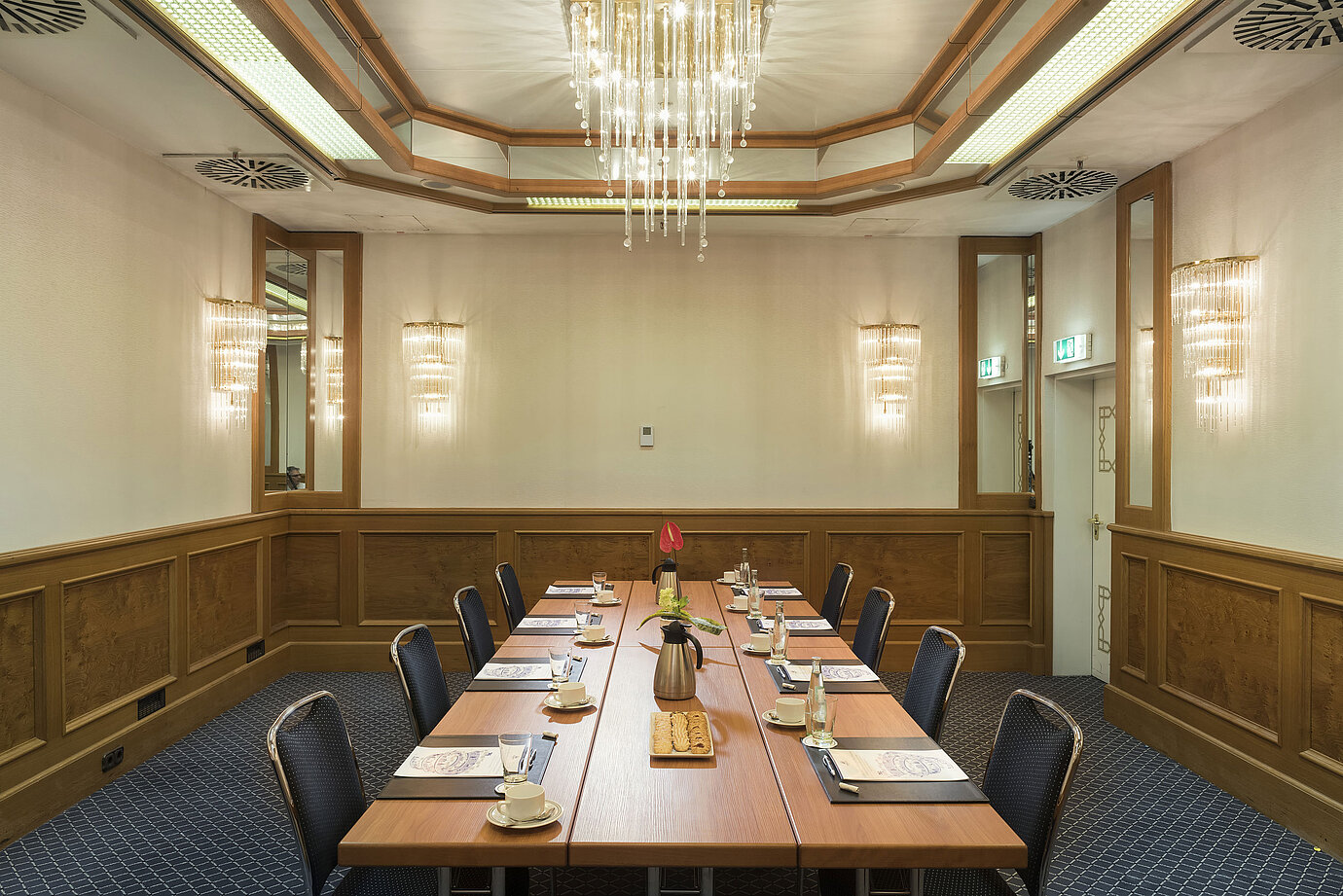 Sala pequeña con café, galletas y flores en el Maritim Hotel Múnich