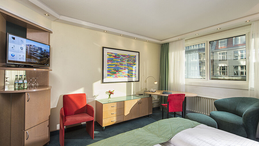 Camera Classic luminosa al Maritim proArte Hotel Berlino con arredi moderni, area salotto accogliente e vista sulla città.