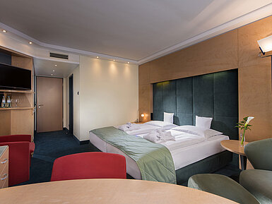 Camera Superior al Maritim proArte Hotel Berlino, con letto matrimoniale, area salotto e illuminazione moderna.
