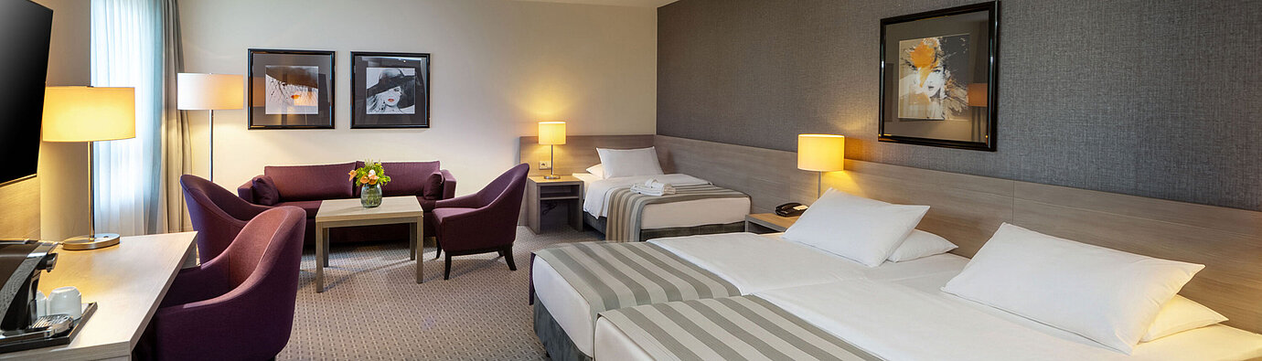 Classic Family room Classic Family Room at Maritim Hotel Königswinter with a double bed, sofa bed and cosy seating area.