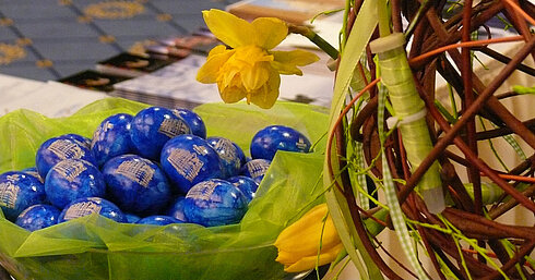 Easter decoration at Maritim Hotel Dresden with blue chocolate eggs, daffodils, and tulips on green table decor.