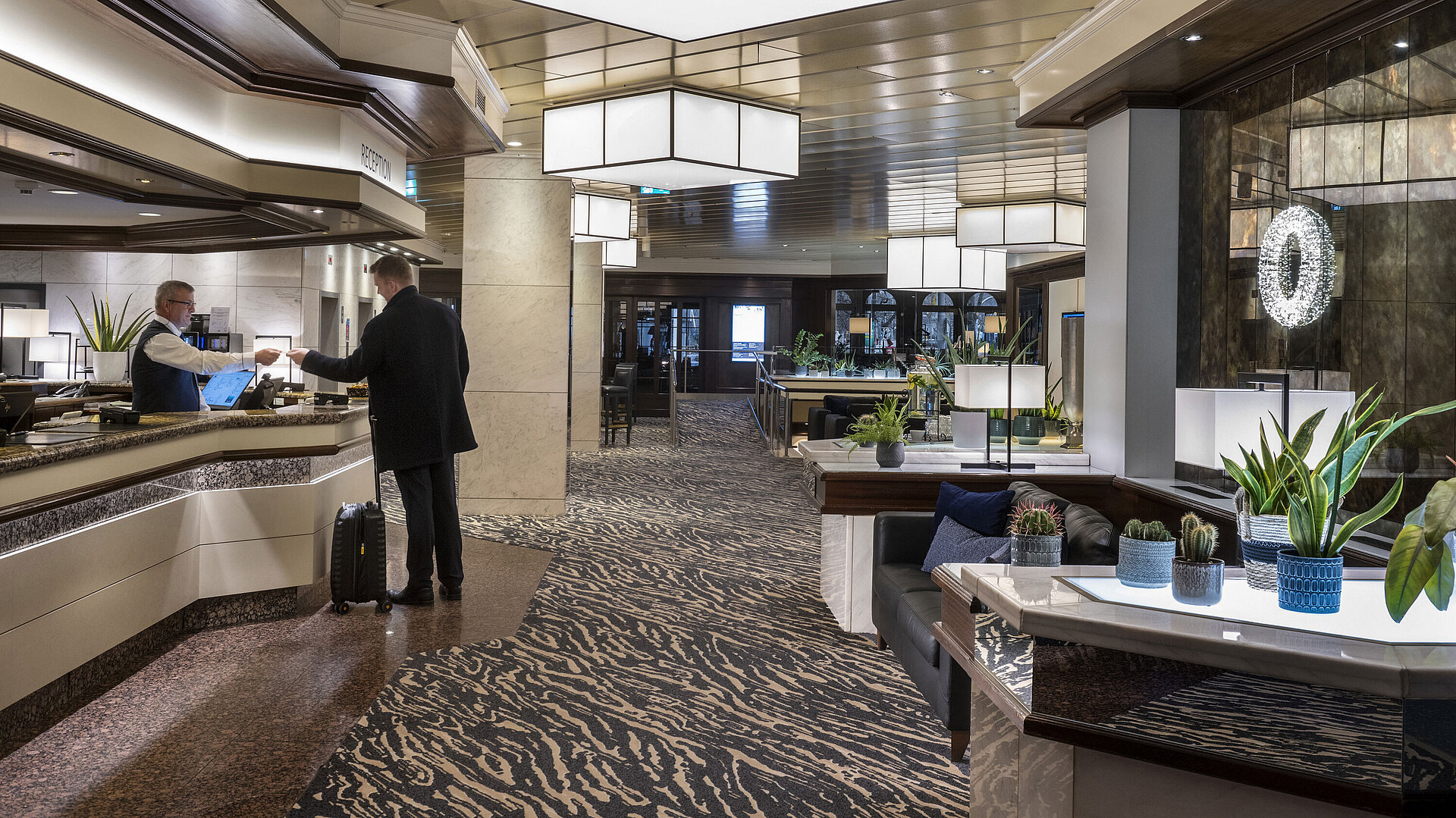 Reception at Maritim Hotel Darmstadt with modern design, friendly staff, and elegant decor.
