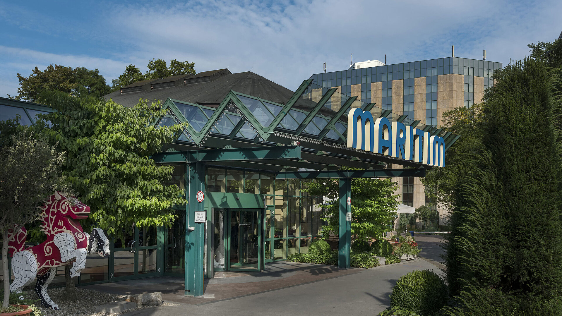 Entrance of the hotel Main entrance of Maritim Hotel Stuttgart with glass roof, green facade and Maritim logo