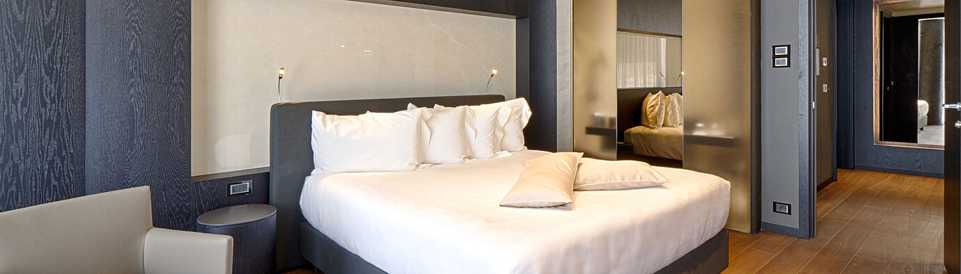 Habitación moderna con cama king size, nicho claro y suelo de madera en el Maritim Hotel Plaza Tirana