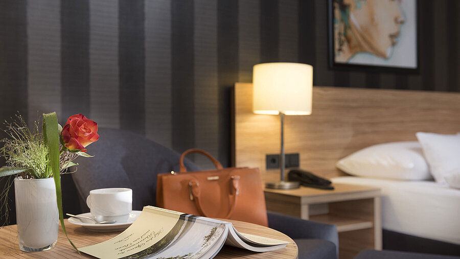 Decoración de mesa elegante en el Maritim Hotel Königswinter con rosa, bolso y ambiente acogedor.