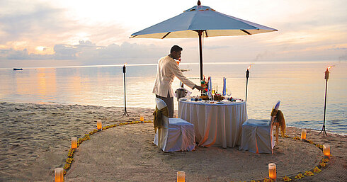 Private dining on the beach Romantic beach dinner at sunset at Maritim Hotel Mauritius