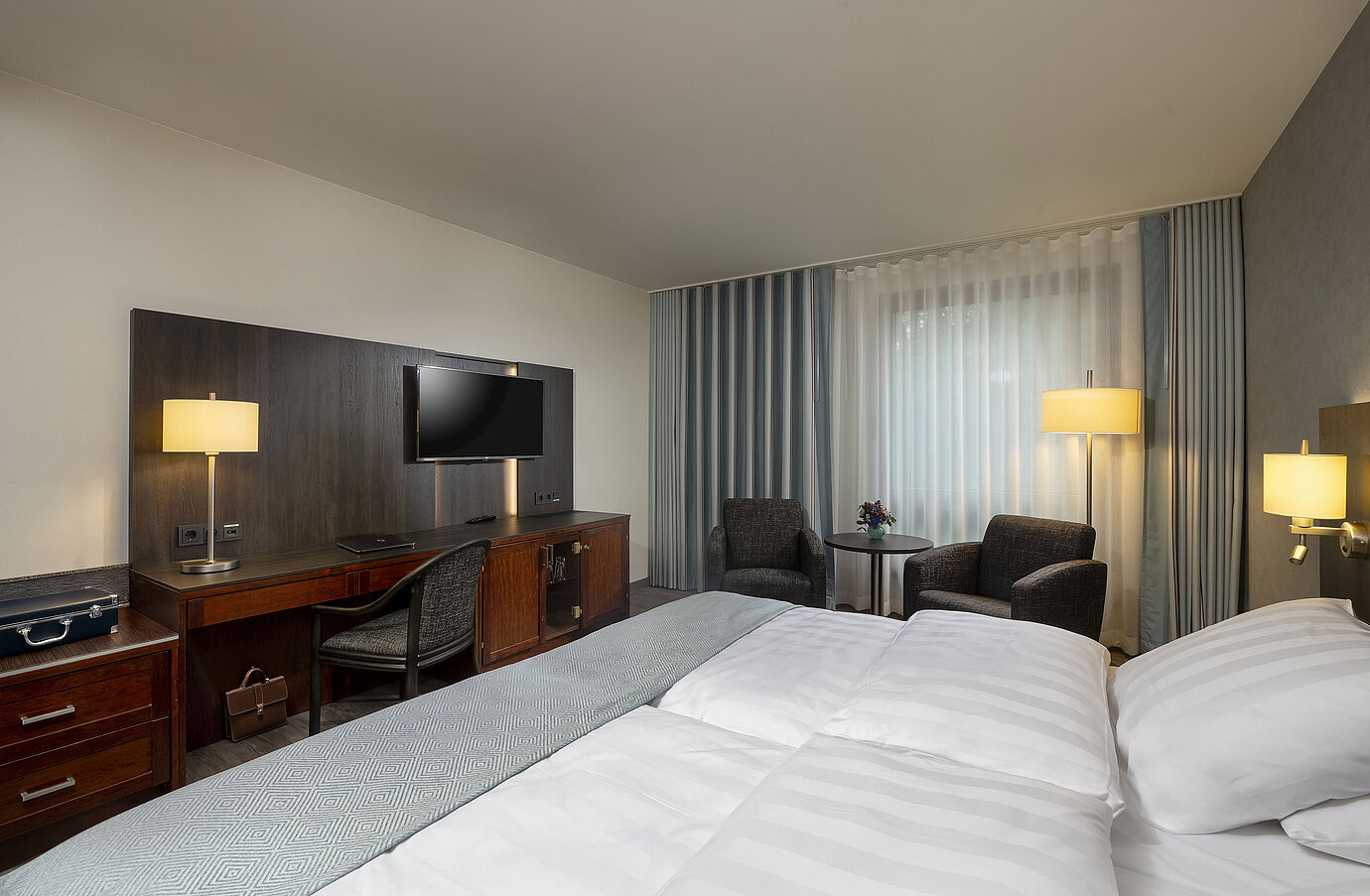 Elegant double room at Maritim Hotel Bremen with modern furnishings, comfortable beds, and a cozy seating area.
