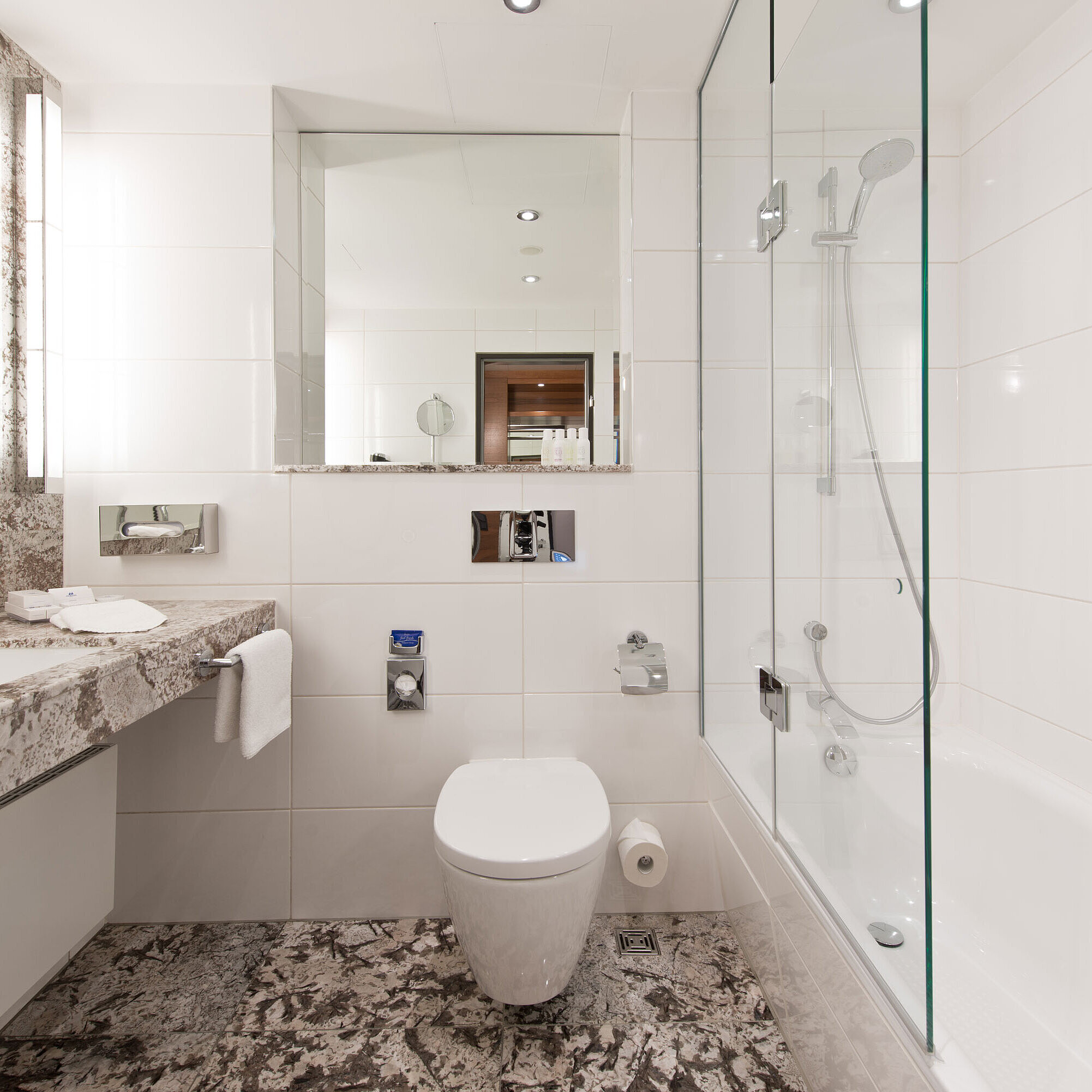 Salle de bain lumineuse à l'hôtel Maritim Bad Homburg avec baignoire moderne et design en marbre élégant.