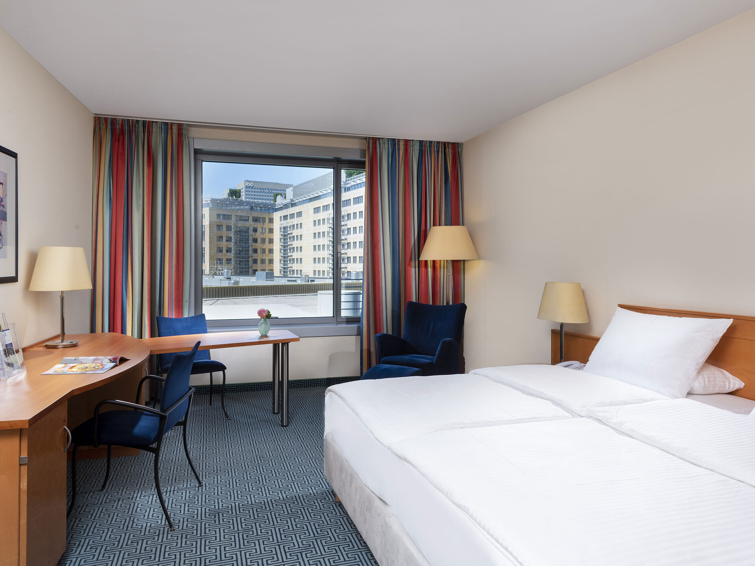 Camera Classic del Maritim Hotel Frankfurt con letto matrimoniale, scrivania e vista sulla città.