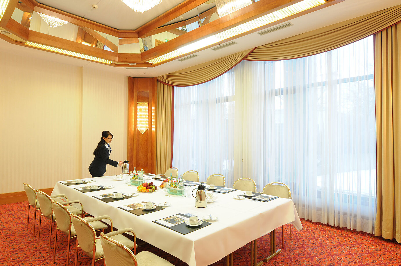 Salle de réunion élégante avec lumière naturelle, table dressée et ambiance chaleureuse au Maritim Hotel Magdeburg.