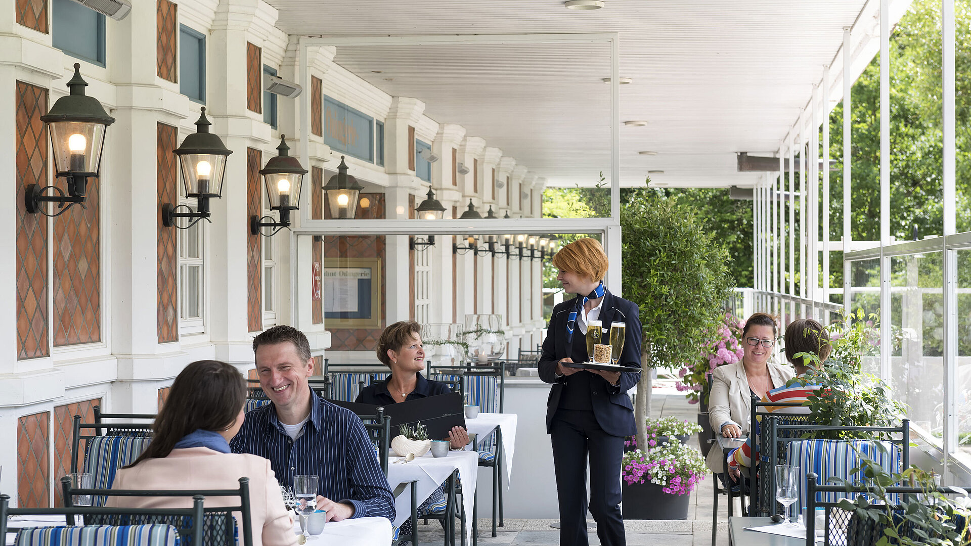 Guests dining and drinking on the terrace of the Friesenstube at Maritim Seehotel Timmendorfer Strand.