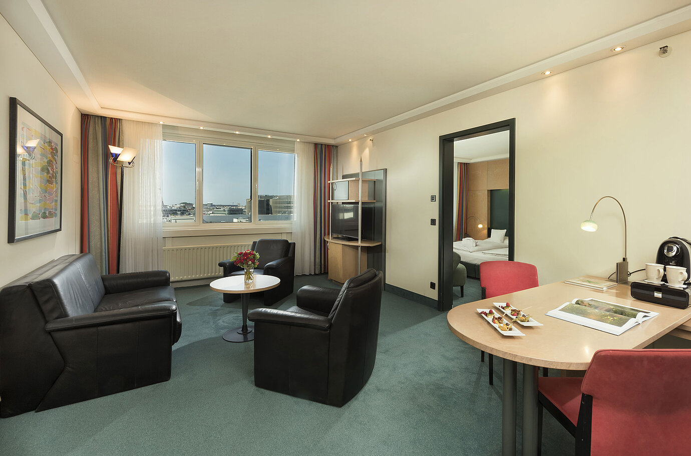 Living area of the Superior Suite at Maritim proArte Hotel Berlin with seating area and window view.