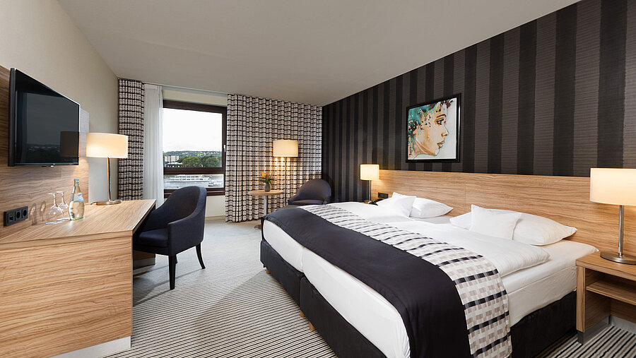 Habitación doble elegante del Maritim Hotel Königswinter con vistas al Rin y diseño moderno.