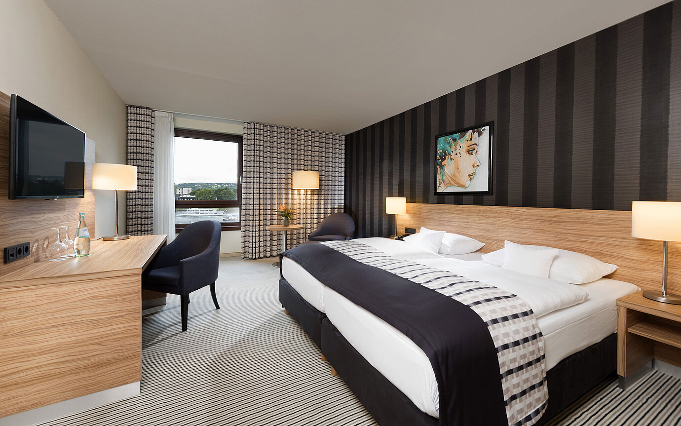 Habitación doble elegante del Maritim Hotel Königswinter con vistas al Rin y diseño moderno.